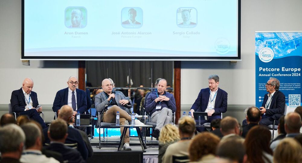 Group of people sitting on the stage and debatting about circularity for PET trays