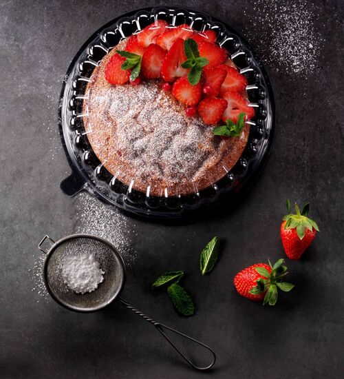 Clear plastic cake packaging with secure hinged lid showcasing a strawberry-topped cake for bakery retail and foodservice distribution.