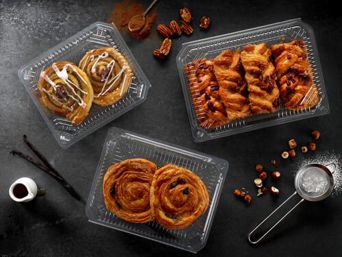 Picture showing a transparent and a black food packaging tray for bakery products with cakes inside