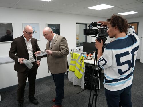 Experts at a packaging manufacturing company reviewing plastic packaging products during a production facility video shoot