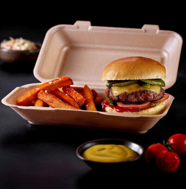 This picture is showing a food packaging tray with burgers and fries inside
