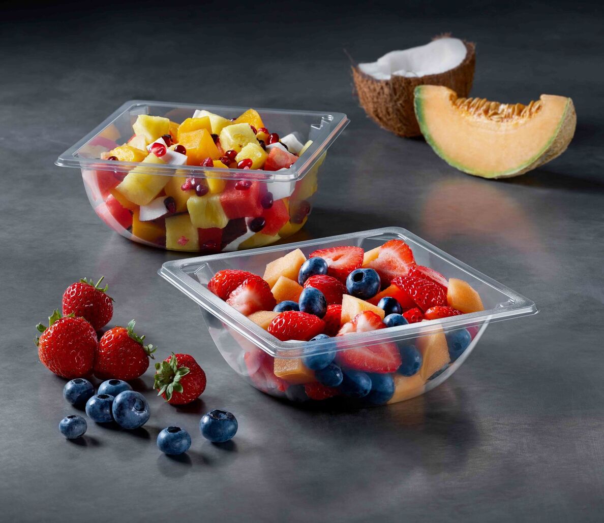 A transparent food packaging tray with various fruit