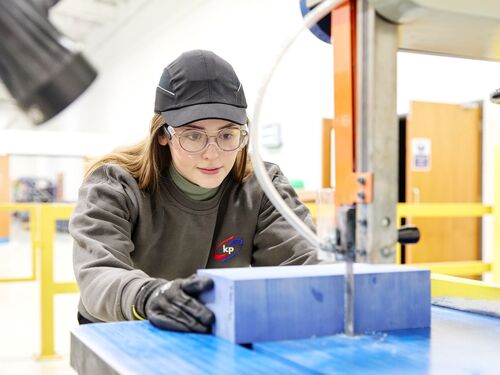 La photo montre une femme travaillant à la production et créant un mannequin de plateau d'emballage alimentaire.