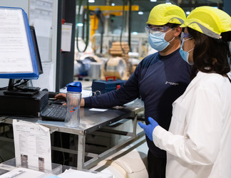 a group of workers are checking the safety regulations plans in the factory