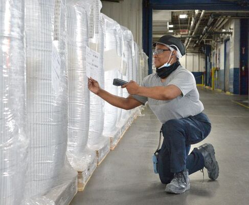 Quality control inspection of flexible plastic packaging products in a B2B manufacturing and distribution facility.