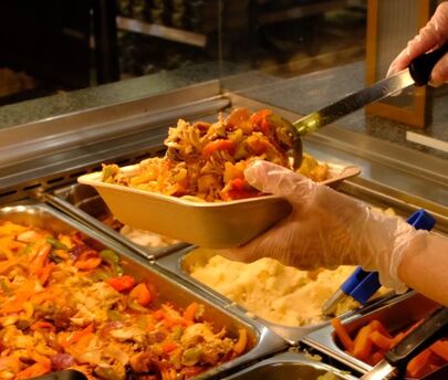 A woman serving Food-to-gofood packaging with a fully recyclable packaging tray from kp made out of EPP
