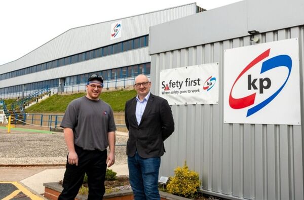 2 male standing in front of the Featherstone production facility