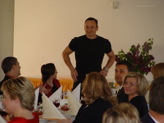 Paul Rawlings standing in front of the audience at company dinner in 2002
