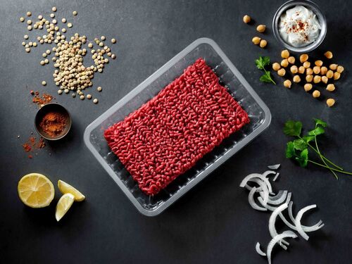 A food packaging tray with meat and vegetables around it