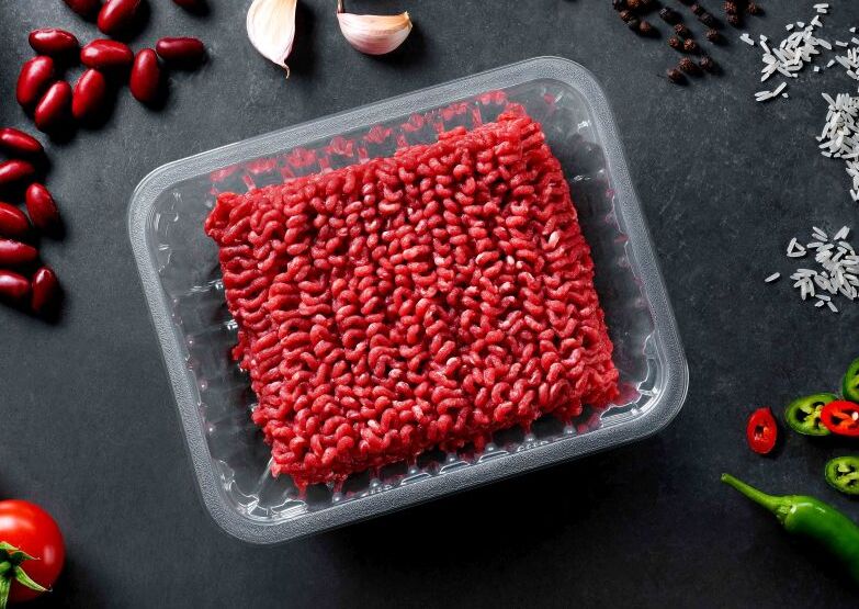 Fresh minced meat in a clear plastic food tray showcasing durable food-grade plastic packaging for meat producers and retailers.