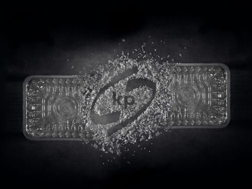 Picture showing a transparent plastic food rigid film with kp logo in the middle created out of plastic flakes