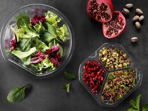 the picture shows two transparent food packaging trays with salad inside