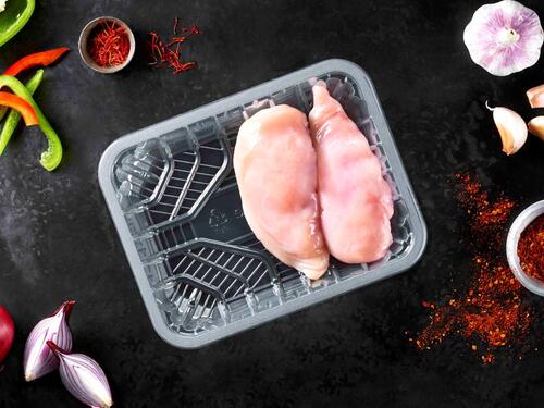 Picture showing a transparant plastic food packaging tray with chicken breast included 