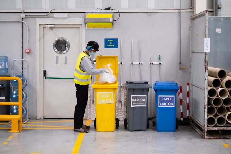 Picture showing a man in production who is recycling waste correctly