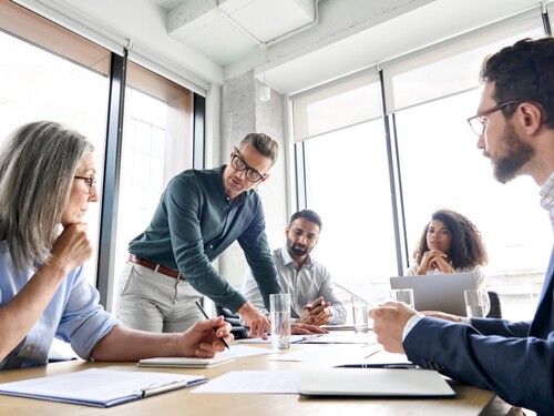 Five colleagues discussing together in a meeting room 