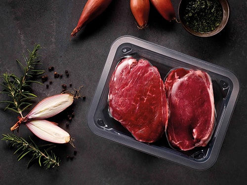 A vacuum skin tray packaging tray contains a beef meat